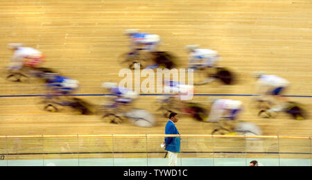 Ein streckenposten Uhren als Radfahrer sprint während der 100-race's Lap olympischen Frauen punkt Endrunde an der Laoshan Velodrom in Peking am 18. August 2008. Niederländische Radfahrer Marianne Vos das Gold mit 30 Punkten, Kubas Yoanka Gonzalez das Silber mit 18 Punkten und dem Spanischen Leire Sanxenxo die Bronze mit 13 Punkten erfasst. (UPI Foto/Stephen Rasierer) Stockfoto