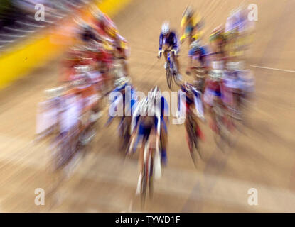 Ein streckenposten Uhren als Radfahrer sprint während der 100-race's Lap olympischen Frauen punkt Endrunde an der Laoshan Velodrom in Peking am 18. August 2008. Niederländische Radfahrer Marianne Vos das Gold mit 30 Punkten, Kubas Yoanka Gonzalez das Silber mit 18 Punkten und dem Spanischen Leire Sanxenxo die Bronze mit 13 Punkten erfasst. (UPI Foto/Stephen Rasierer) Stockfoto