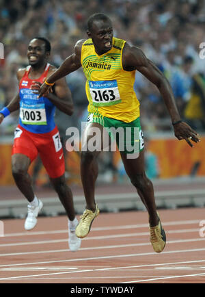 Jamaikas Usain Bolt jubilates erstreckt sich die Ziellinie die Goldmedaille Goldmedaille zu gewinnen und brreak den Weltrekord im 200 Meter Rennen auf dem National Stadium bei den Olympischen Sommerspielen in Peking am 20. August 2008 zu überqueren. Schraube einen neuen Weltrekord von 19,30 Sekunden, brechen die USA Michael Johnson den Rekord von 19.32 im Jahr 1996 eingestellt. Auf der linken Seite ist silbermedaillengewinner Churandy Martina (1003) der Niederländischen Antillen. (UPI Foto/Pat Benic) Stockfoto