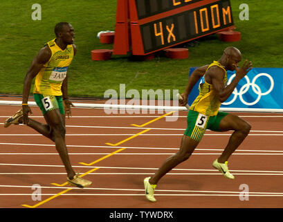 Jamaikas Usain Bolt (L) schreit Teamkollegen Asafa Powell nach ihm übergibt den Staffelstab für die letzte Etappe der Männer 4x100m Staffel finale während der Olympischen Spiele 2008 in Beijing, 22. August 2008. Das Team gewann den Gold und einen neuen Weltrekord mit einer Zeit von 37.10. Trinidad und Tabago Silber mit Japan erfassen Bronze. (UPI Foto/Stephen Rasierer) Stockfoto