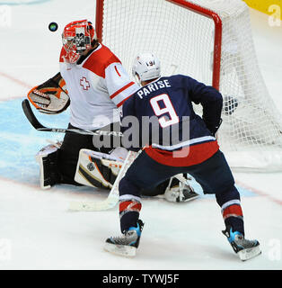 Der Schweizer Jonas Hiller verliert den Puck als USA Zach Parise Angriffen während der dritten Periode in Spiel 1 der Viertelfinale im Canada Hockey Place in Vancouver, Kanada, während der Olympischen Winterspiele 2010 Am 24. Februar 2010. Sekunden später Parise im Rückstoß zu zählen sein erstes Ziel des Spiels blockiert. USA besiegt die Schweiz 2-0, bewegen sie sich auf das Halbfinale. UPI/Roger L. Wollenberg Stockfoto