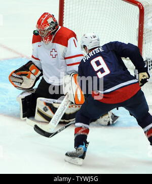 Der Schweizer Jonas Hiller verliert den Puck als USA Zach Parise Angriffen während der dritten Periode in Spiel 1 der Viertelfinale im Canada Hockey Place in Vancouver, Kanada, während der Olympischen Winterspiele 2010 Am 24. Februar 2010. Sekunden später Parise im Rückstoß zu zählen sein erstes Ziel des Spiels blockiert. USA besiegt die Schweiz 2-0, bewegen sie sich auf das Halbfinale. UPI/Roger L. Wollenberg Stockfoto
