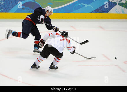Die USA Zach Parise schießt Vergangenheit der Schweizer Mark Streit zu zählen sein zweites Ziel, ein leeres netter, in der dritten Periode in Spiel 1 der Viertelfinale im Canada Hockey Place in Vancouver, Kanada, während der Olympischen Winterspiele 2010 Am 24. Februar 2010. USA besiegt die Schweiz 2-0, bewegen sie sich auf das Halbfinale. UPI/Roger L. Wollenberg Stockfoto