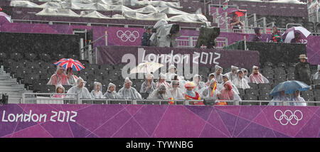 Zuschauer am Strand Volleyball event Shelter der Frauen aus den Regen an der Olympischen Sommerspiele 2012 in London am 29. Juli 2012 in London. UPI/Hugo Philpott Stockfoto