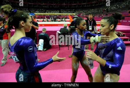 Die USA Jordyn Wieber ist umarmte durch Mannschaftskameraden Gabrielle Douglas als McKayla Maroney schaut (L), nach Wieber wurde nach ihrer Leistung auf dem Schwebebalken während Gymnastik Qualifikation der Frauen am North Greenwich Arena während der Olympischen Sommerspiele 2012 in London Greenwich, London am Juli 29, 2012 verärgert ist. Wieber, der Favorit für die Goldmedaille in der Frau Gymnastik gewinnen alle, bis auf ein paar Veranstaltungen im Team Event gerutscht und nicht für den Rund-um-Event qualifizieren. UPI/Pat Benic Stockfoto