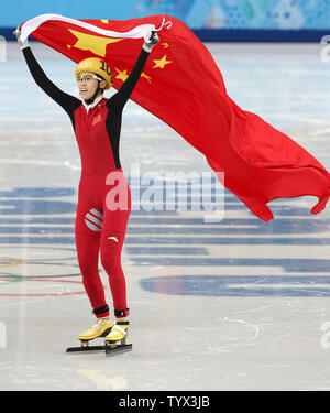 China's Ventilator Kexin hält die Fahne des Landes, während sie ihre silberne Medaille für die Short Track feiert: Damen 1000 m Fall während der olympischen Winterspiele in Sotschi am 21. Februar 2014. UPI/Maya Vidon-White Stockfoto