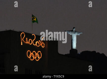 Christus der Erlöser Statue ist neben einem Rio olympische Zeichen am Strand von Copacabana Rio während der Olympischen Sommerspiele 2016 in Rio de Janeiro, Brasilien, am 6. August 2016 gesehen. Foto von Kevin Dietsch/UPI Stockfoto