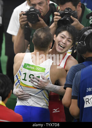 Japanische gymnast Kohei Uchimura (R), im Jubel für den Gewinn der Goldmedaille Umarmungen der Ukraine Oleg Verniaiev, die Silber gewann, zum Abschluß der Männer Turnen Einzel-mehrkampf Finale der Olympischen Sommerspiele 2016 in Rio de Janeiro Rio de Janeiro, Brasilien, 10. August 2016. Großbritanniens Max Whitlock gewann die Bronzemedaille. Foto von Mike Theiler/UPI Stockfoto