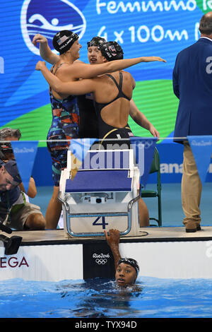 Die USA Simone Manuel, kommt als Teamkollegen zu beenden ist Dana Vollmer, Links, Lilly König und Kathleen Bäcker reagieren nach dem Gewinn der Goldmedaille bei den Frauen 4 x 100m Medley relay-Finale bei den Olympischen Aquatics Stadium am Rio olympische Sommerspiele 2016 in Rio de Janeiro, Brasilien, am 13. August 2016. Die Vereinigten Staaten gewann die Goldmedaille, Australien Silber und Dänemark die Bronze. Foto von Richard Ellis/UPI.. Stockfoto