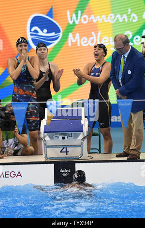 Die USA Simone Manuel, kommt als Teamkollegen zu beenden ist Dana Vollmer, Links, Lilly König und Kathleen Bäcker reagieren nach dem Gewinn der Goldmedaille bei den Frauen 4 x 100m Medley relay-Finale bei den Olympischen Aquatics Stadium am Rio olympische Sommerspiele 2016 in Rio de Janeiro, Brasilien, am 13. August 2016. Die Vereinigten Staaten gewann die Goldmedaille, Australien Silber und Dänemark die Bronze. Foto von Richard Ellis/UPI.. Stockfoto