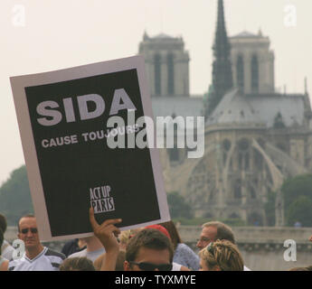 Eine Parade der Teilnehmer trägt ein Zeichen, als er an der Kathedrale Notre Dame auf dem Weg zum Place de la Bastille während die jährliche Gay Pride Parade in Paris, Frankreich, 25. Juni 2005. (UPI Foto/David Silpa) Stockfoto