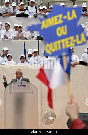 Ein Unterstützer Wellen ein Plakat in der Form der Karte von Frankreich und lesen: "Liebe es oder es lassen", wie die Französische ultranationalistischen Chef Jean-Marie Le Pen liefert eine Rede in Paris, 1. Mai 2006. Tausende von Anhängern der rechtsextremen Partei Front National (FN) vor dem Opernhaus versammelt nach ihren jährlichen Tag der Parade. (UPI Foto/Eco Clement) Stockfoto