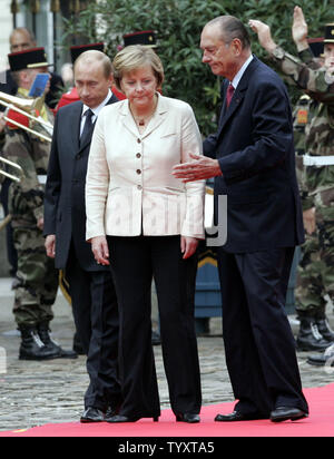 Der französische Präsident Jacques Chirac (R) begrüßt die deutsche Bundeskanzlerin Angela Merkel (C) und der russische Präsident Wladimir Putin Truppen vor dem Dreiergipfel in Compiegne, nördlich von Paris am 23. September 2006 zu überprüfen. Drei Führer haben Spitzengespraech in einem eleganten Chateau mit wirtschaftlichen Fragen offenbar Vorrang vor dem umstrittenen Atomprogramm des Iran statt. (UPI Foto/Anatoli Zhdanov) Stockfoto