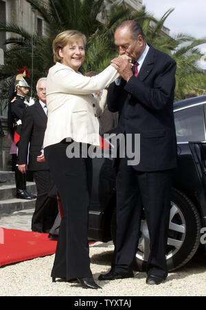 Der französische Präsident Jacques Chirac (R) Küsse hand von Bundeskanzlerin Angela Merkel am Ende der 3-Wege-Gipfel in Compiegne, nördlich von Paris am 23. September 2006. Die Staatsoberhäupter von Frankreich, Deutschland und Russland haben Spitzengespraech in einem eleganten Chateau mit wirtschaftlichen Fragen offenbar Vorrang vor dem umstrittenen Atomprogramm des Iran statt. (UPI Foto/Anatoli Zhdanov) Stockfoto