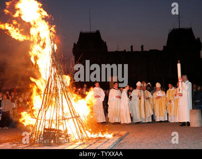 Priester und Gläubige versammeln sich um ein zeremonielles Feuer in der Osternacht Ritual vor der Kathedrale Notre Dame in Paris am 7. April 2007. Das Ritual symbolisiert die Auferstehung Jesu und wird von der Überwindung der Finsternis vertreten. (UPI Foto/David Silpa) Stockfoto