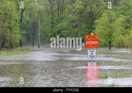 Starke Regenfälle und Stürme haben übergelaufen ist, Flüssen und Bächen, die straßensperrung Warnzeichen in der überfluteten Straße Standorten installiert werden. Stockfoto