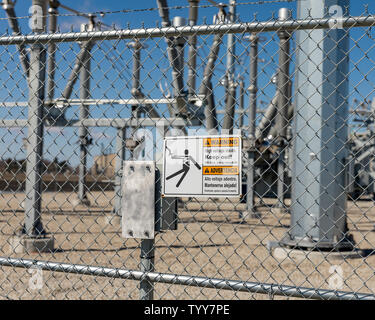 Hohe Spannung Warnzeichen zeigt Stromschlaggefahr an einer Kette Link Zaun eine Unterstation mit Strom versorgt Stockfoto