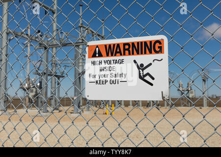 Hohe Spannung Warnzeichen zeigt Stromschlaggefahr an einer Kette Link Zaun eine Unterstation mit Strom versorgt Stockfoto