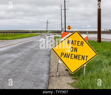 Wasser auf Fahrbahn Warnzeichen wegen Überflutung von schwere Regenfälle und Stürme im Mittelwesten auf der Straße platziert Stockfoto