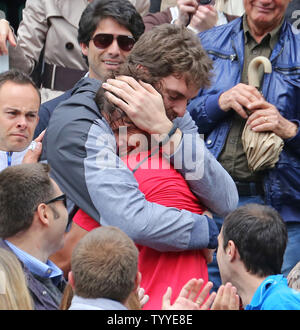 Der Spanier Rafael Nadal (rotes Hemd) umfasst Los Angeles Laker und Landsmann Pau Gasol nach Nadal final der French Open Männer Match gegen den Serben Novak Djokovic in Roland Garros in Paris am 11. Juni 2012 gewonnen. Nadal besiegt Djokovic 6-4, 6-3, 2-6, 7-5 in einem Spiel, dass eines Tages wegen des Regens seine Aufzeichnung 7 French Open Titel zu gewinnen verzögert wurde. UPI/David Silpa Stockfoto