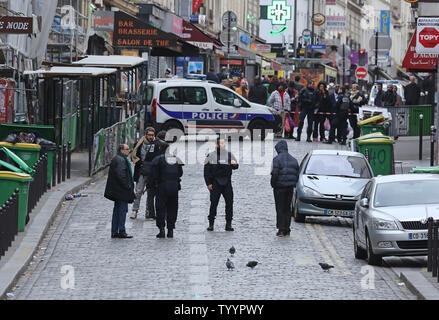 Die Polizei in der Nähe der Rue de la Fontaine-au-Roi in Paris am 14. November 2015 gesehen. Ein Cafe auf der anderen Straßenseite war einer der Orte, die von einer Reihe von koordinierten Attacken in der ganzen Stadt, die mindestens 120 Menschen das Leben gekostet. Der Islamische Staat (ISIS) hat die Verantwortung für die Angriffe behauptet. Foto von David Silpa/UPI Stockfoto