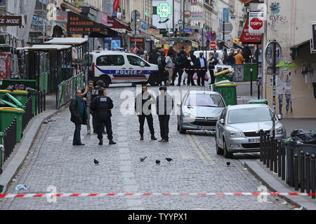 Die Polizei in der Nähe der Rue de la Fontaine-au-Roi in Paris am 14. November 2015 gesehen. Ein Cafe auf der anderen Straßenseite war einer der Orte, die von einer Reihe von koordinierten Attacken in der ganzen Stadt, die mindestens 120 Menschen das Leben gekostet. Der Islamische Staat (ISIS) hat die Verantwortung für die Angriffe behauptet. Foto von David Silpa/UPI Stockfoto