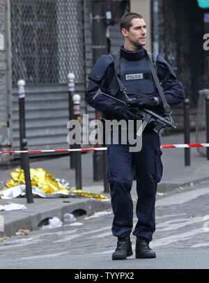 Die Polizei in der Nähe der Rue de la Fontaine-au-Roi in Paris am 14. November 2015 gesehen. Ein Cafe auf der anderen Straßenseite war einer der Orte, die von einer Reihe von koordinierten Attacken in der ganzen Stadt, die mindestens 120 Menschen das Leben gekostet. Der Islamische Staat (ISIS) hat die Verantwortung für die Angriffe behauptet. Foto von David Silpa/UPI Stockfoto