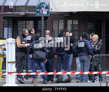 Die Polizei in der Nähe der Rue de la Fontaine-au-Roi in Paris am 14. November 2015 gesehen. Ein Cafe auf der anderen Straßenseite war einer der Orte, die von einer Reihe von koordinierten Attacken in der ganzen Stadt, die mindestens 120 Menschen das Leben gekostet. Der Islamische Staat (ISIS) hat die Verantwortung für die Angriffe behauptet. Foto von David Silpa/UPI Stockfoto