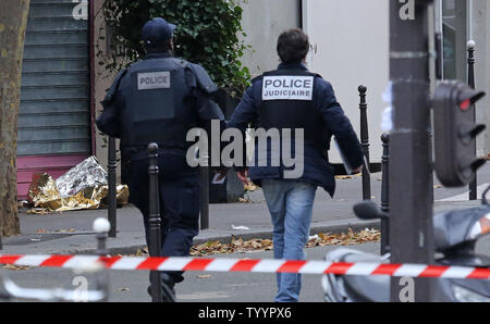 Die Polizei in der Nähe der Rue de la Fontaine-au-Roi in Paris am 14. November 2015 gesehen. Ein Cafe auf der anderen Straßenseite war einer der Orte, die von einer Reihe von koordinierten Attacken in der ganzen Stadt, die mindestens 120 Menschen das Leben gekostet. Der Islamische Staat (ISIS) hat die Verantwortung für die Angriffe behauptet. Foto von David Silpa/UPI Stockfoto