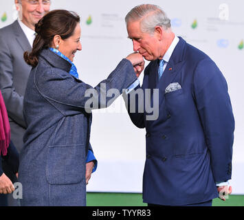 Prince Charles in Großbritannien (R) Küsse die Hand der französische Umweltminister Segolene Royal am 21. Klimakonferenz der Vereinten Nationen in Le Bourget bei Paris am 30. November 2015. Die fast 150 Staats- und Regierungschefs und Vertreter aus 200 Ländern anwesend wird versuchen, eine rechtlich bindende Vereinbarung weltweit die CO2-Emissionen mit dem Ziel, die globale Erwärmung auf unter 2 Grad Celsius zu begrenzen, zu verhandeln. Foto von David Silpa/UPI Stockfoto