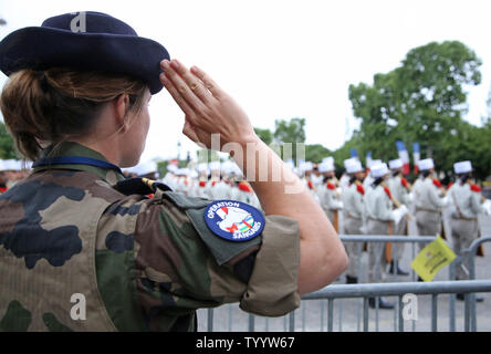 Ein französischer Soldat begrüßt Sie während der Wiedergabe des französischen Nationalhymne entlang der Avenue des Champs-Elysees am jährlichen Tag der Bastille Militärparade in Paris am 14. Juli 2016. Foto von David Silpa/UPI Stockfoto