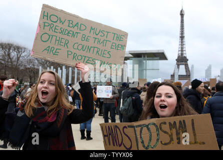 Anti-Trump Demonstranten halten Plakate und Parolen schreien, als sie durch die Straßen von Paris, den Eiffelturm, am 4. Februar 2017. Tausende marschierten in den europäischen Hauptstädten von Paris, Berlin und London zu verlangen, dass die neu gewählte US-Präsident Donald Trump Schritte aus dem Amt. Foto von Maya Vidon-White/UPI Stockfoto