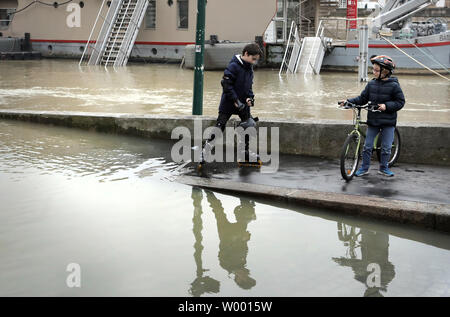 Bewohner prüfen die geschwollenen Wasser des Flusses Seine folgenden sintflutartigen Regenfällen in Paris am 27. Januar 2018. Die französische Hauptstadt blieb auf Flood Alert nach dem Fluss seine Banken Burst, Verlassen Straßen überflutet und zwingen Teil der unteren Ebene der berühmte Louvre zu schließen. Foto von Maya Vidon-White Stockfoto