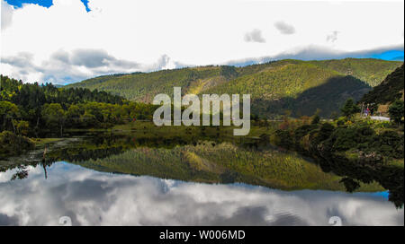 Green mountain auf einem weißen wolkigen Tag mit einem klaren Reflexion in den See. Stockfoto