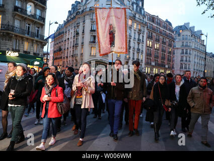 Christliche jugendliche Singen während einer Prozession nach einem riesigen Feuer der Kathedrale Notre Dame in Paris Links 16. April 2019 schwer beschädigt. Der französische Präsident Emmanuel Längestrich schwor die Gebäude aus dem 13. Jahrhundert, in der sich Millionen von Gläubigen und Touristen pro Jahr neu zu erstellen. Foto von Eco Clement/UPI Stockfoto