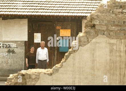 Zheng Zhanlin, 75, (R) und seiner Frau Wu Shuqin, 77, stehen vor Ihrer bald abgerissen werden Haus im Zentrum von Peking, 17. Mai 2006. Dieses Bild wurde am Süden Dawn Alley auf der Chongwen District Seite der Qianmen, ein Entertainment-, Handels- und Wohnviertel der berühmten seit seiner Gründung in den frühen 1400er Jahren. Auf prime Immobilien im Süden - zentrales Peking Minuten entfernt vom Platz des Himmlischen Friedens, Zheng und seine Frau sind einige der Tausende von langfristig Aufenthaltsberechtigte gezwungen zu verlegen weg für eine Fußgängerzone und gehobenen Wohnungsbau Sanierung zu machen, bevor die Summe werden entfernt Stockfoto