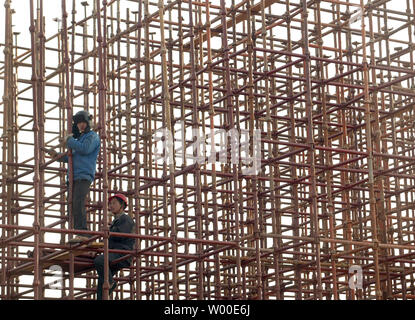 Chinesische Bauarbeiter montieren Gerüste aus Metall auf einer Baustelle im Zentrum von Peking, China, am 20. Februar 2006. China wird "Schwerwiegend" beschäftigungspolitischen Herausforderungen in diesem Jahr und ist wahrscheinlich weniger als die Hälfte der benötigten Arbeitsplätze mit rasch wachsenden Armeen von neuen Arbeitssuchenden zu erstellen und der entlassene Arbeitnehmer, wirtschaftlichen Planer des kommunistischen Landes in eine düstere Prognose sagte. Die städtischen Gebiete in China müssen Sie rund 25 Millionen Arbeitsplätze bis Neueinsteiger in den Arbeitsmarkt einweichen, den Verlust von Arbeitsplätzen aus staatlichen Unternehmen und ländliche Job Jäger, der Nationalen Kommission für Entwicklung und Reform (N Stockfoto