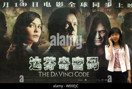 Eine chinesische Frau Gespräche auf Ihrem Handy in der Nähe einer Bushaltestelle Plakatwerbung der Veröffentlichung von "Der Da Vinci Code" in der Innenstadt von Peking, 23. Mai 2006. Ein Beijing Publikum wurde der erste, um zu sehen, "Der Da Vinci Code', wenn es wurde gezeigt Mittwoch, schlagen die offizielle Cannes Premiere von Stunden in einer Bewegung, die Hollywood's Bemühungen der chinesischen Zuschauer woo unterstrichen. "Da Vinci" gegeben wird, die größte Version noch nicht für einen ausländischen Film in China, mit einigen 393 Drucke zu den Theatern, dem Rekord von 380 Drucke von "King Kong" im vergangenen Jahr, sagte Li Chow, General Manager in Peking für Verteiler Columbia Stockfoto