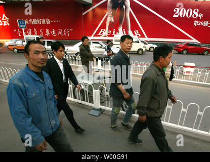 Chinesische Fußgänger Spaziergang entlang einer Straße vorbei an einem riesigen Olympischen billboard Förderung Ticketverkauf im Zentrum von Peking, China am 05 Mai, 2997. (UPI Foto/Stephen Rasierer) Stockfoto
