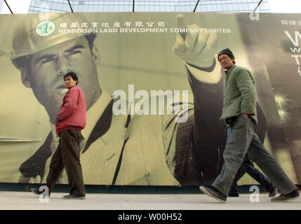 Chinesische Wanderarbeiter Spaziergang, vorbei an einem großen plakatwerbung Eine neue internationale Business Komplex in der Innenstadt von Peking, China, am 9. Januar 2008. Der chinesische Präsident Hu Jintao hat geschworen, "wirksame Maßnahmen" die steigenden Lebensmittelpreise zu bändigen und einem boomenden Immobilienmarkt daß Eigenschaft Preise sky-Rakete, staatliche Presse sagte letzte Woche gesehen hat. (UPI Foto/Stephen Rasierer). Stockfoto