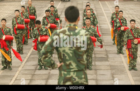Junge chinesische Peoples' Liberation Army Soldaten pratice traditionelle Tänze mit Fahnen, Trommeln und Zimbeln in Ritan Park, ein Park mitten im Diplomatenviertel, in Peking am 12. Mai 2008. (UPI Foto/Stephen Rasierer) Stockfoto