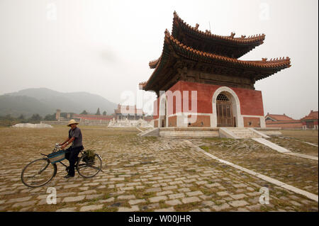 Ein chinesischer Bauer fahrräder Vergangenheit einer der Kaiserlichen Gräber der Qing Dynastie, auch als die Mandschu-dynastie, der das letzte herrschende Dynastie Chinas von 1644 bis 1912 und sind in Zunhua, Provinz Hebei gelegen, nur ein paar Stunden östlich von Peking am 21. September 2008 bekannt. Die Gräber sind von der UNESCO als Weltkulturerbe gelistet. Chinesische Beamte schauen die Werbung der Olympischen Spiele zu ziehen mehr westliche Reisende und helfen, neues Leben in Tourismus Industrie der chinesischen Hauptstadt atmen zu nutzen. (UPI Foto/Stephen Rasierer) Stockfoto