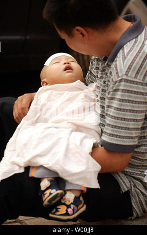 Ein chinesischer Vater bringt seinen Sohn in ein Kinderkrankenhaus in Peking am 23. September 2008. China schwor giftige Milch von Prozessoren und auf den Exportmärkten nach verdorbenen infant Pulver zu stoppen, die mehr als 54.000 Kinder in einem Skandal, den Ruf des Landes in einer neuen Krise verstrickt ist krank. (UPI Foto/Stephen Rasierer) Stockfoto