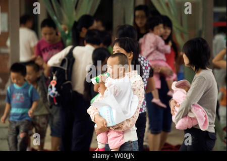 Chinesische Eltern bringen ihre Kinder in ein Kinderkrankenhaus in Peking am 23. September 2008. China schwor giftige Milch von Prozessoren und auf den Exportmärkten nach verdorbenen infant Pulver zu stoppen, die mehr als 54.000 Kinder in einem Skandal, den Ruf des Landes in einer neuen Krise verstrickt ist krank. (UPI Foto/Stephen Rasierer) Stockfoto