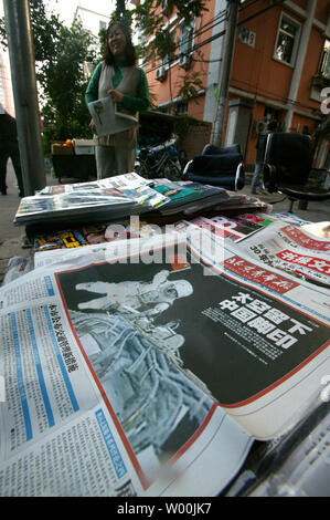 Ein chinesischer Hersteller neigt ihr News stand, mit Zeitungen, Chinas erster Weltraumspaziergang geschmückt, in Peking am 28. September 2008. Drei chinesischen Astronauten sicher wieder auf der Erde am Sonntag nach der ersten des Landes spacewalk, mit einem Held willkommen in Erwartung der Männer, deren Reise der Nation in ihren Bann. (UPI Foto/Stephen Rasierer) Stockfoto