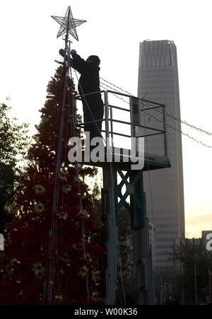 Ein chinesischer Arbeiter hängt leuchtet auf einem riesigen Weihnachtsbaum, oder ein 'Baum des Lichts" nach Angaben der staatlichen Medien, errichtet auf dem Rasen eines kommerziellen Komplex im Central Business District von Peking November 28, 2008. China offiziell nicht erkennen das Christentum oder Weihnachten, aber inoffizielle schätzt die Zahl auf fast 10 Millionen getauften Christen in dem Land leben, das fast eine Million Menschen in der gesamten Bevölkerung. (UPI Foto/Stephen Rasierer) Stockfoto