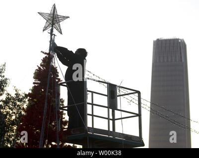 Ein chinesischer Arbeiter hängt leuchtet auf einem riesigen Weihnachtsbaum, oder ein 'Baum des Lichts" nach Angaben der staatlichen Medien, errichtet auf dem Rasen eines kommerziellen Komplex im Central Business District von Peking November 28, 2008. China offiziell nicht erkennen das Christentum oder Weihnachten, aber inoffizielle schätzt die Zahl auf fast 10 Millionen getauften Christen in dem Land leben, das fast eine Million Menschen in der gesamten Bevölkerung. (UPI Foto/Stephen Rasierer) Stockfoto