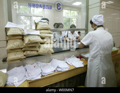 Chinesische Patienten warten bis der Traditionellen Chinesischen Medizin (TCM) Pakete verschiedener Kräuter in Peking Traditionelle Chinesische Medizin Krankenhaus in Peking am 23. Juli 2009 aufzuheben. Um die TCM in vollem Umfang spielen in der Prävention und Behandlung der Grippe vom Typ A H1N1, Schweinegrippe, die Pekinger Verwaltung der TCM zu bringen, hat einen speziellen Dienst für Leute, die Kräuter Pakete zu bekommen, dass die Ärzte behaupten wird helfen, H1N1-Infektion zu verhindern. (UPI Foto/Stephen Rasierer) Stockfoto