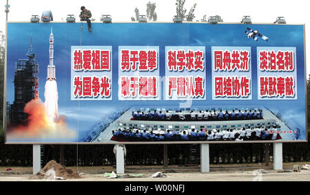 Ein chinesischer Arbeiter installiert leuchtet auf einem riesigen Reklametafeln feiert China's space Program in der Nähe von Pekings Tempo Stadt" am 6. Oktober 2009. China ist aggressiv Beschleunigung der bemannten Raumfahrt durch die Entwicklung einer 17.000 lb. bemannten Militärische Raumfahrt Labor, die bis Ende 2010 geplant. Die Mission wird mit einem Halt in den USA übereinstimmen, die bemannte Raumfahrt mit der Phase-out des Shuttles. UPI/Stephen Rasierer Stockfoto