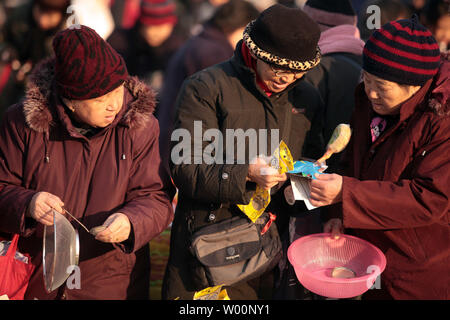 Chinesische shop für Schnäppchen auf einen "Flohmarkt" in Peking am 21. Dezember 2009. Trotz Wirtschaftswachstum Chinas Erholung von der globalen Finanzkrise, des Landes Zeitungen berichten über eine langsame, die in die Konsumausgaben für Luxusgüter. UPI/Stephen Rasierer Stockfoto